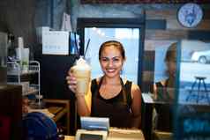 这是订单肖像年轻的咖啡师持有冷冻咖啡饮料咖啡商店