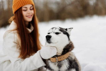 女人<strong>纯</strong>种狗雪走<strong>玩</strong>休息新鲜的空气