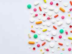 有创意的布局色彩斑斓的药片胶囊绿色背景最小的医疗概念制药科维德平躺药物治疗处方药片病毒疫情