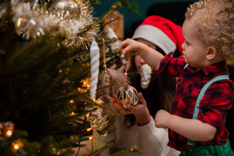 妹妹帮助年轻的哥哥挂饰品圣诞节树