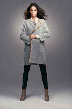 惊人的冬天高级定制时装工作室拍摄时髦穿着年轻的女人灰色的背景