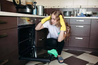 女人黄色的保护手套脏烤箱首页厨房