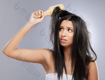 遵循好头发护理实践防止损害工作室拍摄年轻的女人损坏的头发摆姿势灰色背景