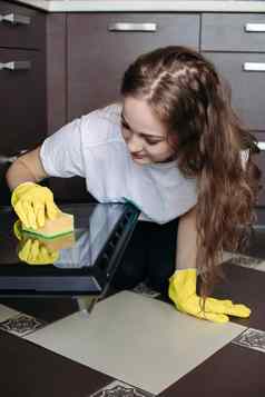 女人穿保护手套破布清洁烤箱厨房