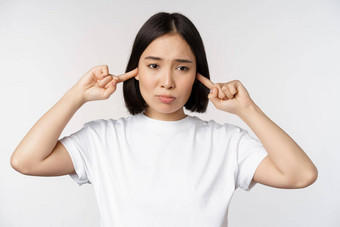 肖像亚洲女人关闭<strong>耳朵</strong>感觉不舒服大声噪音烦人的声音站白色背景