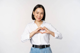 爱<strong>手势</strong>美丽的亚洲年轻的女人显示<strong>心手势</strong>微笑表达护理感情站白色背景