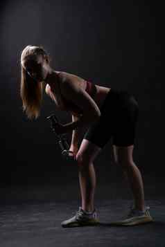 哑铃站美丽的女孩黑色的背景凯拉奈特莉女孩哑铃黑色的身体女适合健康的活跃的强度运动服装肱二头肌护理ABS健美运动员
