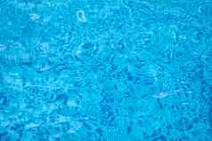 背景水蓝色的游泳池水表面太阳反射