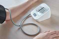 女人测量血压力数字压力监控蓝色的背景健康护理医疗概念