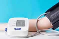 女人测量血压力数字压力监控蓝色的背景健康护理医疗概念