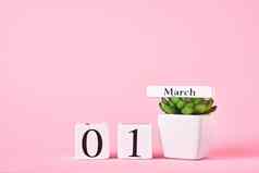 木块日历日期3月植物粉红色的背景春天概念