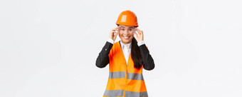 微笑漂亮的女亚洲工程师建设经理安全头盔眼镜协议enterting建筑区域企业站白色背景