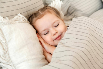 迷人的女孩睡觉床上金发女郎睡觉甜美床上白色亚麻的地方文本健康的孩子