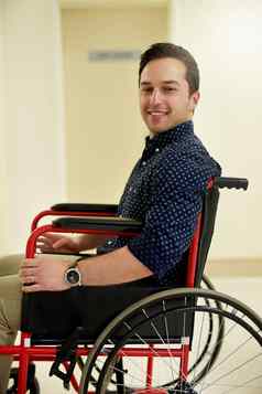 理疗会话肖像年轻的男人。坐着轮椅医院