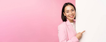 图像亚洲女企业家西装指出手指董事会显示smth白色墙展示图表信息站粉红色的工作室背景