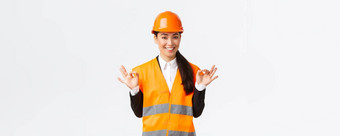架构师使完美的计划自信亚洲女工程师安全头盔显示手势控制很高兴<strong>优秀</strong>的结果站白色背景