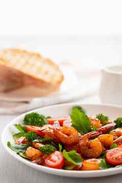 新鲜的沙拉虾西红柿芝麻菜草本植物白色板垂直图像