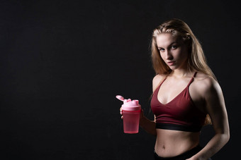 手持有瓶粉红色的女孩斯波特斯曼黑色的背景瓶粉红色的体育锻炼健康生活方式体育运动教练运动员运动服装人汗水重量空空间