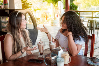 可爱的女孩谈话咖啡商店女朋友讨论的想法咖啡商店