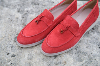 女人的红色的时尚的仿麂皮游手好闲的人鞋子石头背景一对时尚的女<strong>休闲鞋</strong>鞋子在<strong>户外</strong>