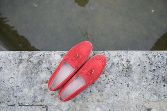 女人的红色的时尚的仿麂皮游手好闲的人鞋子石头背景一对时尚的女休闲鞋鞋子在户外