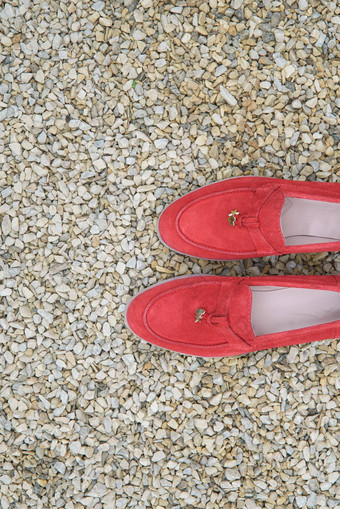 女人的红色的时尚的仿麂皮游手好闲的人鞋子石头背景一对时尚的女<strong>休闲鞋</strong>鞋子在<strong>户外</strong>