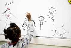 五岁的女孩吸引了家庭黑板上慈善中心支持适应难民移民孩子们孩子们