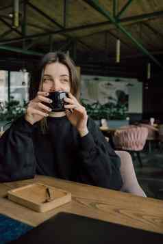 女人享受杯茶咖啡热饮料眼睛