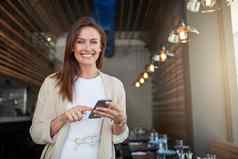 确保业务蓬勃发展的肖像年轻的企业家发短信手机咖啡馆