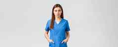 医疗保健工人防止病毒保险医学概念严肃的表情自信年轻的医疗工人护士医生蓝色的实习医生风云持有手口袋相机