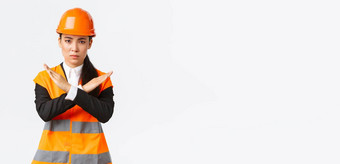 严肃的表情美联储亚洲女老板建设经理安全头盔显示交叉手势停止禁止危险的行动失望结果禁止