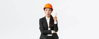 有创意的聪明的女亚洲建设工程师伟大的的想法站安全头盔西装提高指数手指认为建议发现解决方案分享计划白色背景