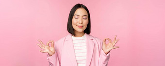 平静微笑年轻的亚洲女人冥想实践瑜伽正念放松工作呼吸吸入空气很高兴脸站粉红色的背景