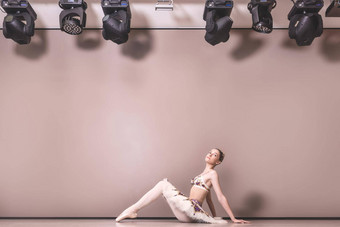 年轻的美丽的优雅的高加索人芭蕾舞女演员实践芭蕾舞职位图图裙子经典芭蕾舞舞者坐着地板上芭蕾舞工作室