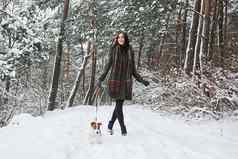 快乐老板宠物女人温暖的衣服走狗雪森林前面视图