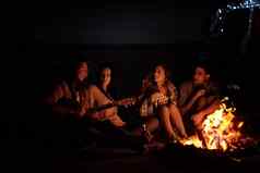 感觉自由拍摄集团朋友坐着篝火海滩晚上
