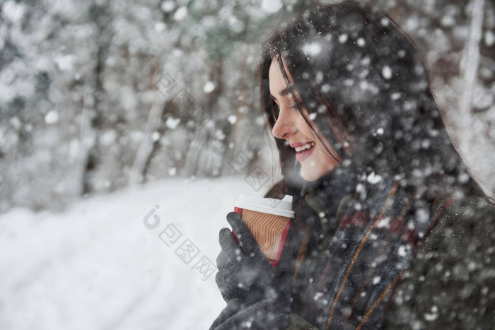 下降雪森林女孩温暖的衣服杯咖啡走冬天森林