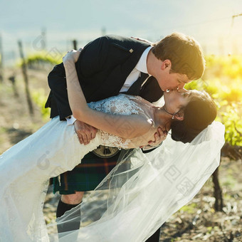 惊人的吻拍摄快乐的新娘新郎分享吻葡萄园一天