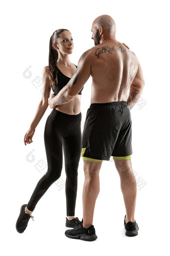 运动男人。黑色的短裤运动鞋浅黑肤色的女人女人紧身裤前摆<strong>姿势</strong>孤立的白色背景<strong>健身</strong>夫妇<strong>健身</strong>房概念