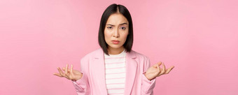 肖像年轻的亚洲业务女人女售货员耸肩膀困惑笨smth站粉红色的背景