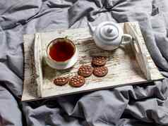 室内首页安逸概念前视图杯茶茶壶Herbal茶糖碗木白色托盘床上瓷杯