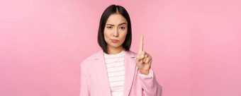 亚洲女商人有关脸表达式显示停止运动禁忌禁止手势不赞成smth坏站粉红色的背景
