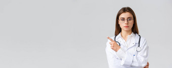 医疗保健工人医学保险科维德流感大流行概念严肃的表情专业女医生护士白色实习医生风云眼镜指出手指左横幅诊所信息