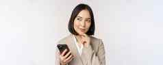 关闭肖像朝鲜文女人企业夫人西装移动电话微笑持有智能手机站白色背景
