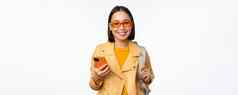 时尚的年轻的亚洲女人旅游旅行者背包智能手机微笑相机摆姿势白色背景