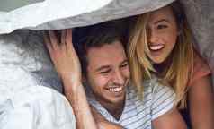 冒险羽绒被拍摄快乐年轻的夫妇有趣的羽绒被床上
