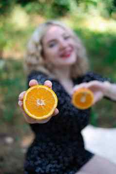 肖像迷人的金发女郎十几岁的女孩新鲜的橙色在户外森林公园美味的多汁的水果