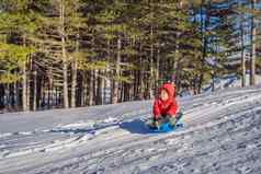 快乐积极的男孩享受滑雪橇冷天气户外冬天有趣的活动概念