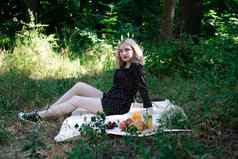 迷人的金发女郎年轻的女人野餐格子公园美味的零食柠檬水水果羊角面包夏季休息放松享受自由