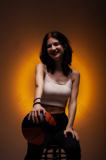 十几岁的女孩牙科牙套持有篮球工作室肖像橙色彩色的背景